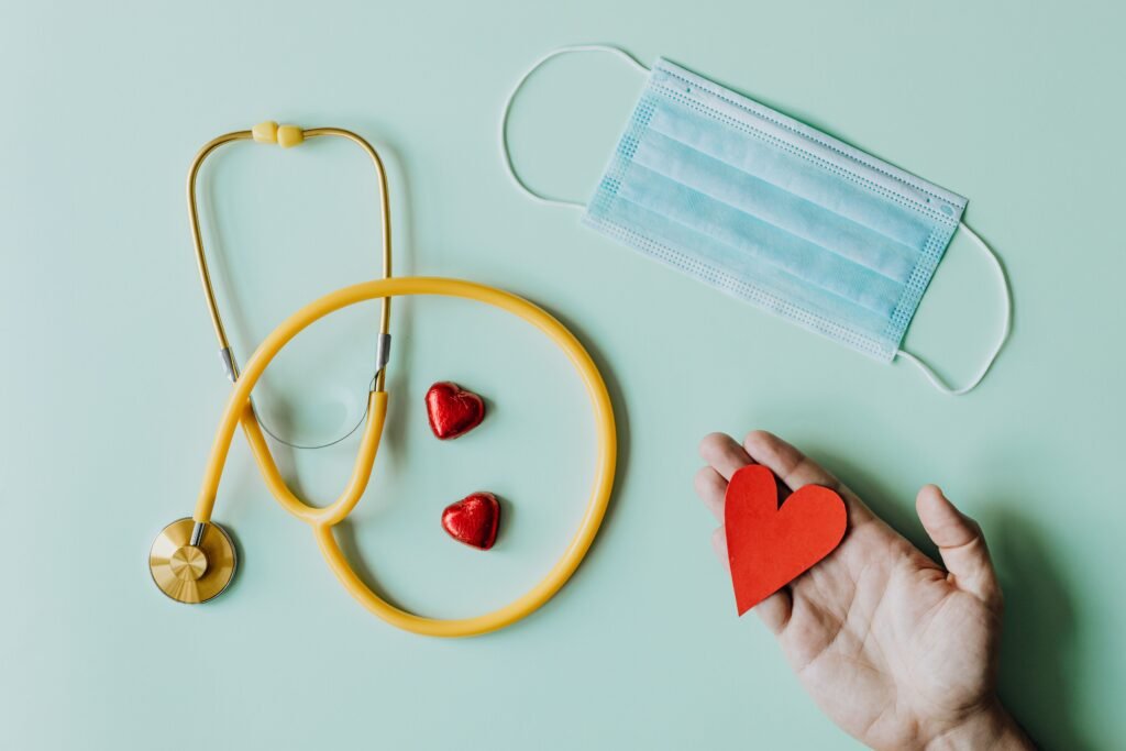 Terapias y Sesiones Top view of crop anonymous person hand with red paper heart on table with stethoscope and medical mask for coronavirus prevention